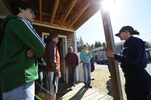 Lt. Ashly Thomas, right, of the Southwest Harbor Sector Field Office, talks with eighth grade, science students from Tremont Consolidated School in Bass Harbor, Maine, about ’green’ energy.  Photo by Etta Smith © SW